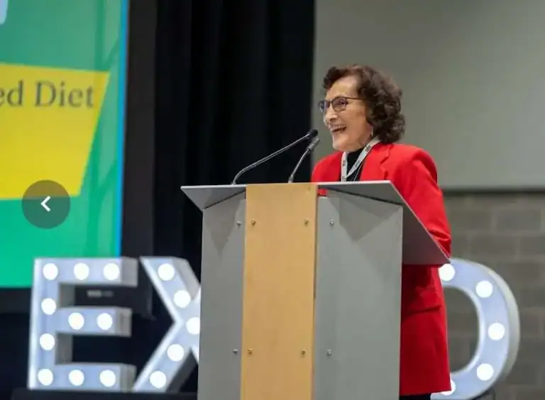Professional woman delivering a presentation on nutrition topics at a conference or seminar.