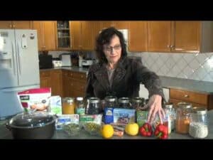 Woman organizing glass jars and produce in kitchen.