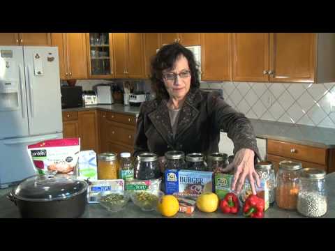 Woman organizing glass jars and produce in kitchen.