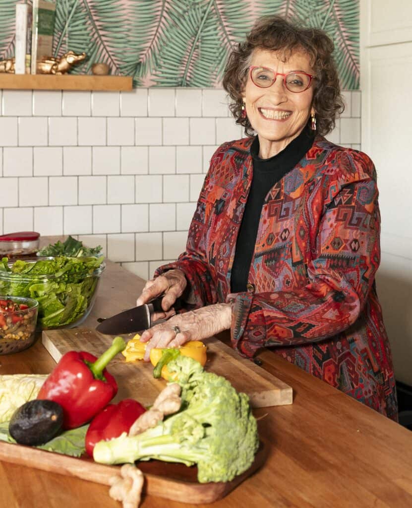 Smiling woman chopping vegetables in kitchen